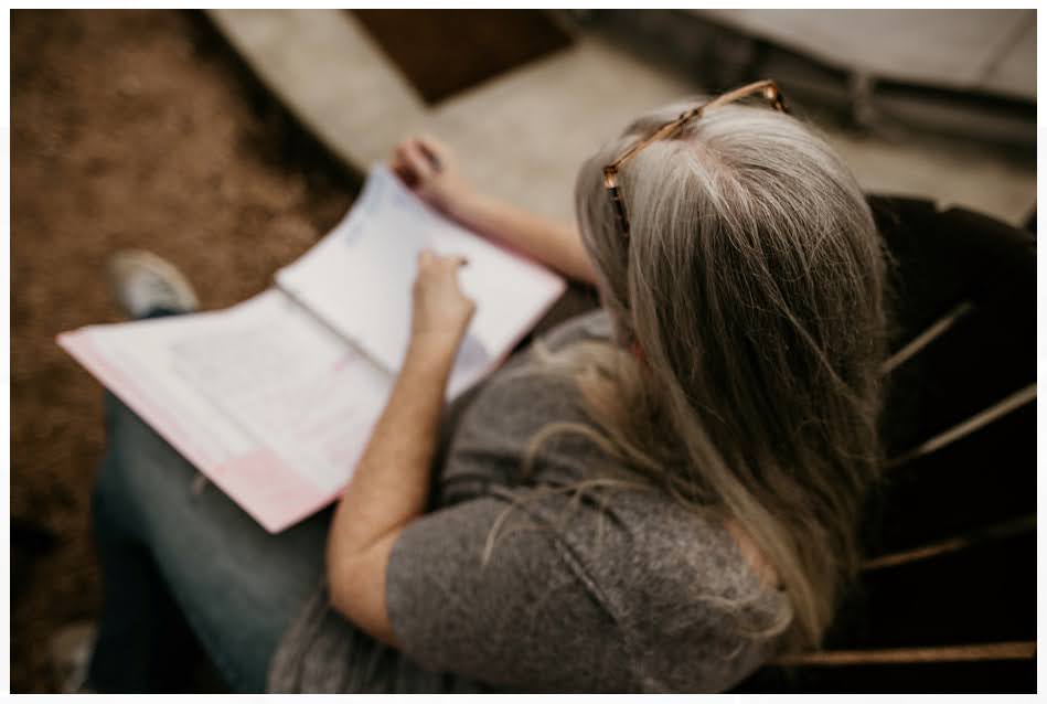 Becky, founder of Blynn & Blossom, writing in an open notebook.